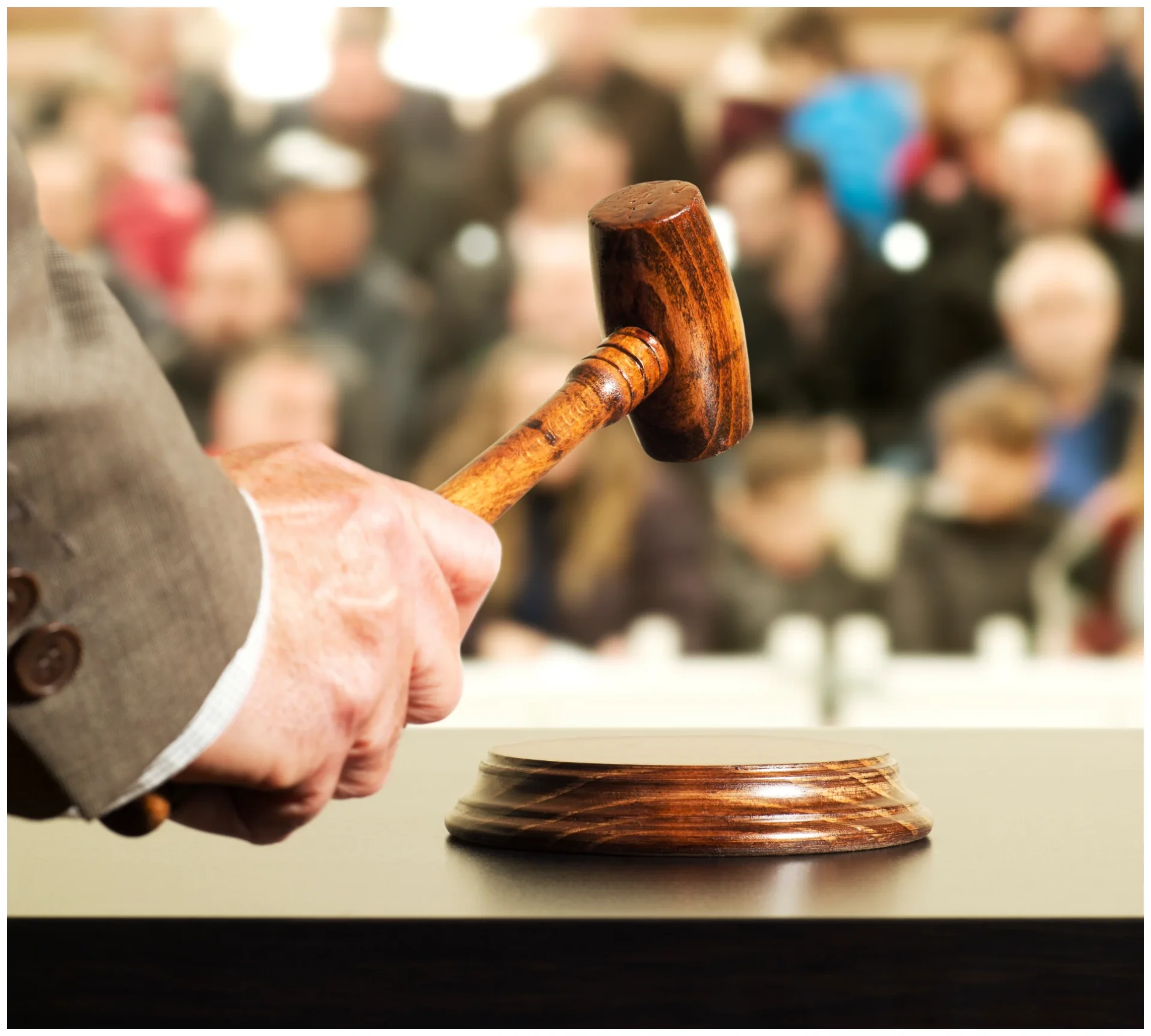 Hand holding a wooden gavel