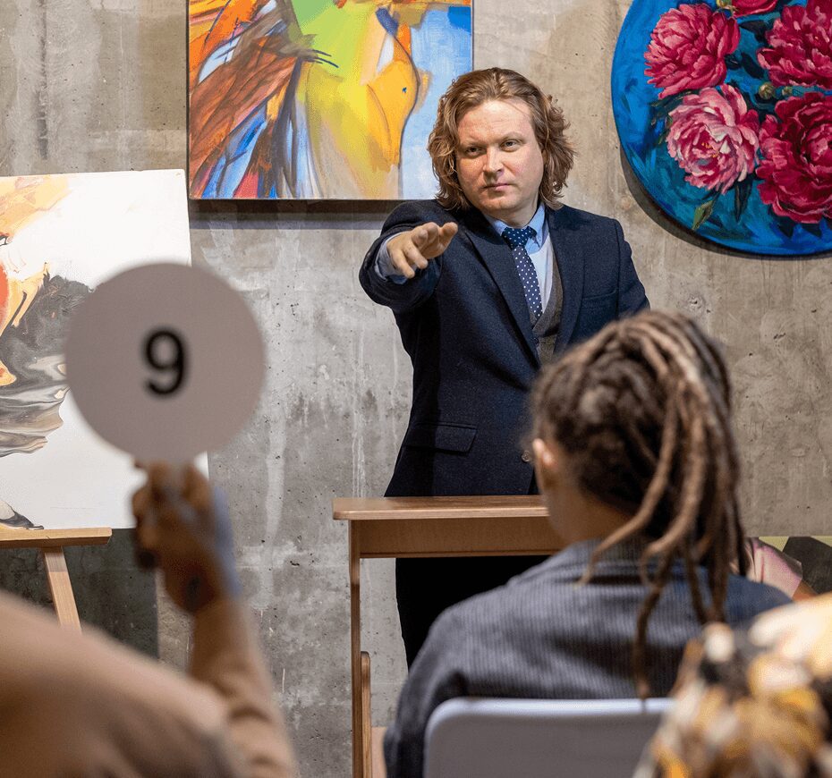 Auctioneer selling paintings